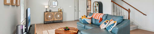 A living room with a blue couch and a wooden coffee table.