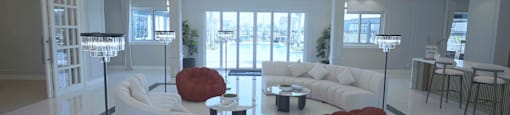 A modern living room with a white sofa and a red chair.