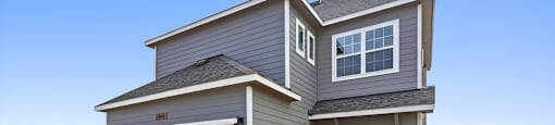 A modern house with a grey exterior and a white garage door.
