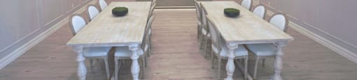 A large dining room with a long table and chairs.