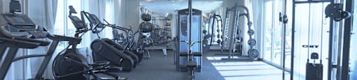 A spacious gym with treadmills, elliptical machines, and weightlifting equipment.