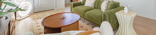 A living room with a green couch and a wooden table.