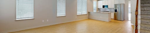 A room with a ceiling fan and wooden flooring.