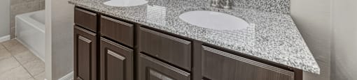 A bathroom with a granite countertop and a white sink.
