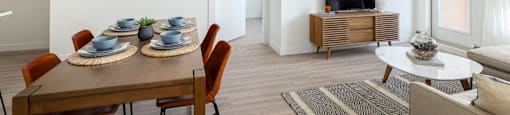 a living room with a dining room table and a television