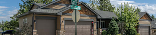 A house with a garage and a street sign in front of it.