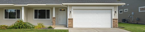A house with a garage door and a driveway.