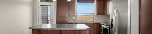 A kitchen with brown cabinets, an island, and stainless steel appliances.