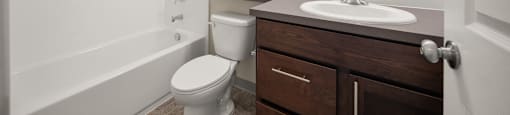 A bathroom with a toilet, sink, and bathtub.