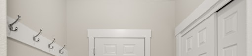 A room with a bench along the wall and a closet.