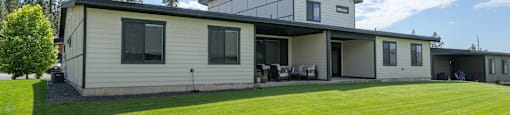A modern house with a large lawn in front.