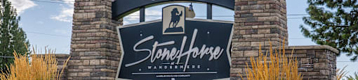 A sign that says Stonehorse at Wandermere surrounded by greenery.