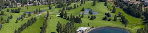 A golf course with a lake and a small building.