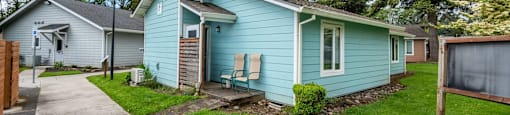 a blue house with a sidewalk in front of it
