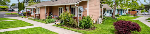 a small pink house with a sidewalk in front of it