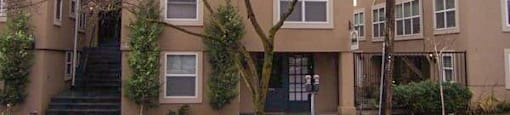the outside of three buildings with trees in front