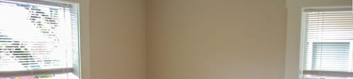 an empty bedroom with wooden floors and white walls