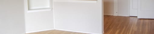 an empty room with white shelves and a door