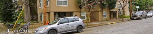 the side of a building with a car parked in front of it