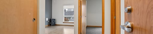A hallway with a door on the left and another door on the right.