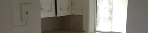a kitchen with white cabinets and a stove and a window