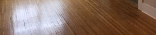 an empty living room with wood floors and a window