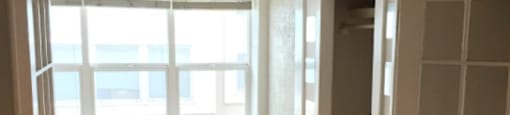 an empty room with a window and wooden floors