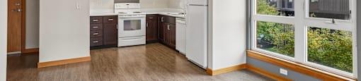 A kitchen with white appliances and wooden cabinets.