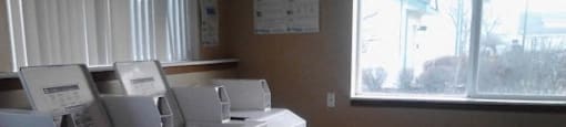 a row of white washers and dryers in a room