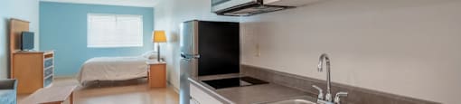 A kitchen with a sink and a refrigerator.