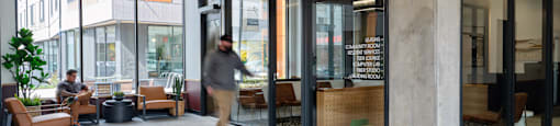 A man is walking through a modern office lobby.