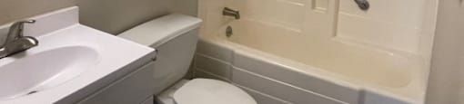 A white toilet sits next to a sink in a bathroom.