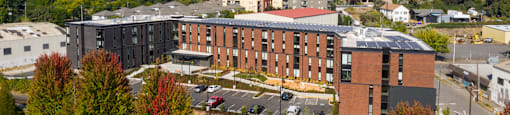 an aerial view of a large brick building with a city in the background