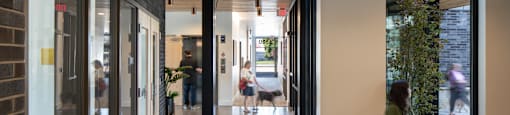 a woman sits on a bench in a lobby of a building