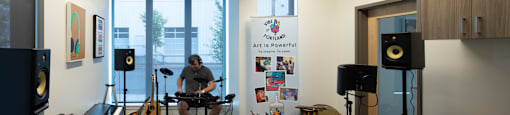 a man playing a guitar in a room with musical equipment