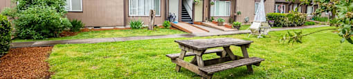 a picnic table in a yard in front of a building