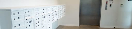 A room with a row of lockers and a door.