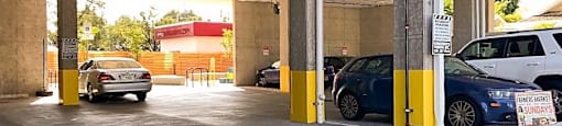 A parking garage with cars parked in yellow spaces.