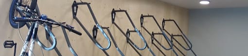 A bicycle is hanging on a rack with several other bicycles.