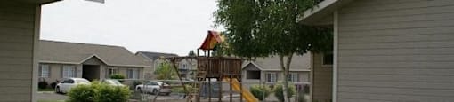 a yard with a swing set in the backyard of a house