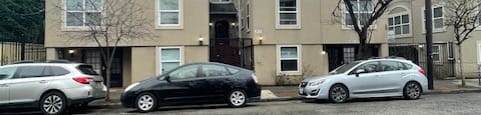 three cars parked in front of an apartment building