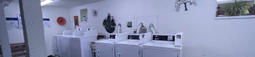 a laundry room with four washing machines in it