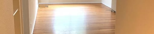 an empty room with wooden floors and a window