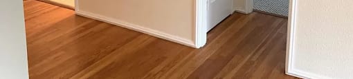 an empty room with a wooden floor and a closet