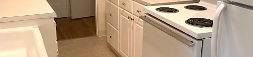 a kitchen with white appliances and white cabinets