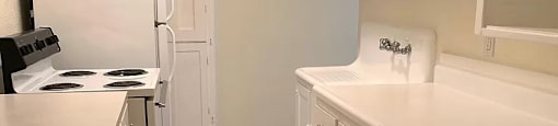 a white kitchen with white cabinets and white appliances