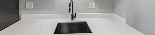 A kitchen with white cabinets and a sink.