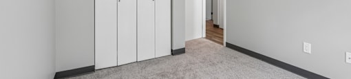 A room with a carpeted floor and a white door.