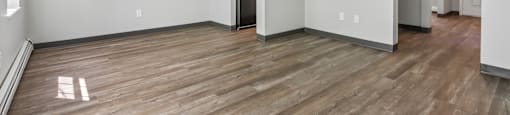 A room with wood flooring and white walls.
