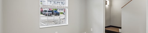 A room with a wood floor and a picture of a building on the wall.